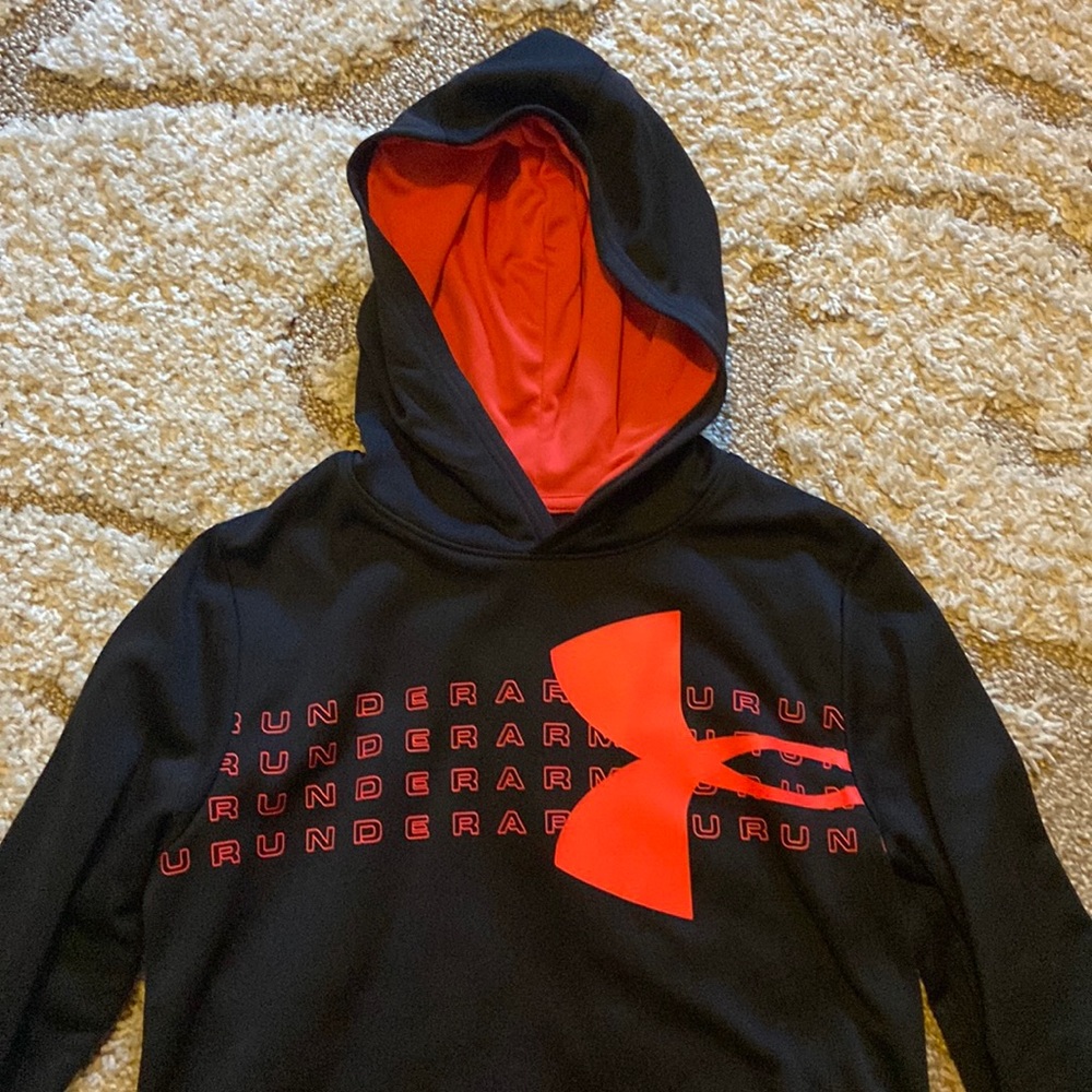 Black/bright orange Under Armour hoodie w center front pocket. 100% polyester.